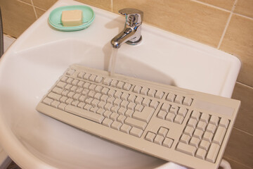 Cleaning concept washing keyboard to remove grime in bathroom.