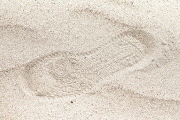 Fototapeta na wymiar The imprint of sports shoes in the sand.