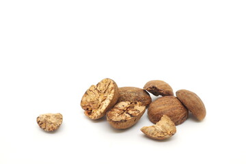 Dried whole and cracked nutmeg seeds or Myristica fragrans spice isolated on white background.