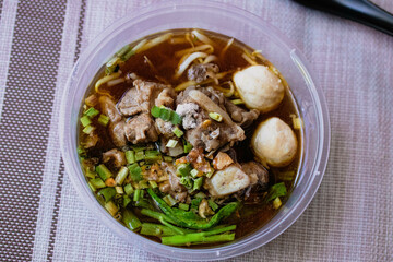 Braised pork and meatballs in a plastic cup.Delivery Food Box