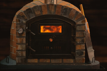 Traditional wood fired pizza oven in Italian restaurant. Oven made from bricks and cast iron.