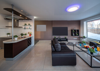 Modern interior of spacious studio apartment. Black leather furniture