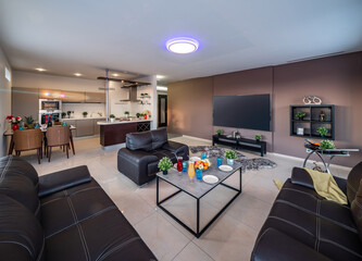 Modern interior of spacious studio apartment. Black leather furniture