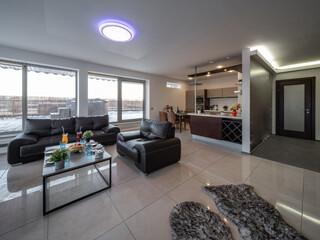 Modern interior of spacious studio apartment. Black leather furniture