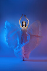 Art beautiful woman in blowing flying dress. Freedom concept in neon color light. Fashion style of flowing dress on body woman. Flying Dress Fluttering on Wind