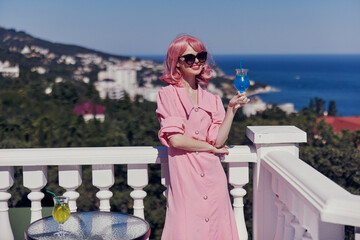 portrait of beautiful woman drinking a cocktail on the terrace Happy female relaxing