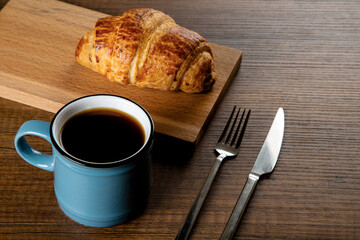 Croissant with a cup of full coffee,directly above	