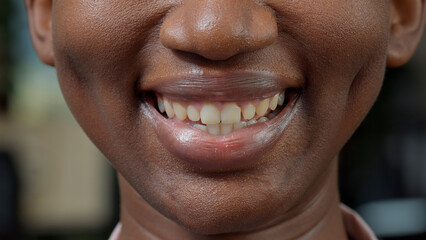 Macro shot of female person moving her lips on camera, showing candid smile and natural healthy skin. Young woman feeling confident with positive facial expressions. Authentic emotions. © DC Studio