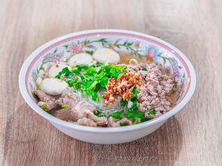 Top view of pork noodles meatball clear soup, braised pork spare ribs noodles without soup on the wooden table.