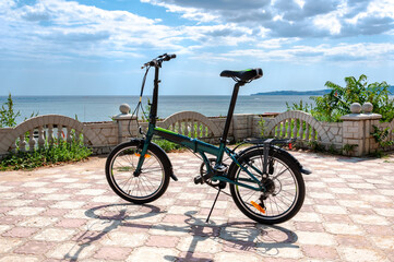 Fototapeta premium A folding bike stands on the Black Sea embankment.