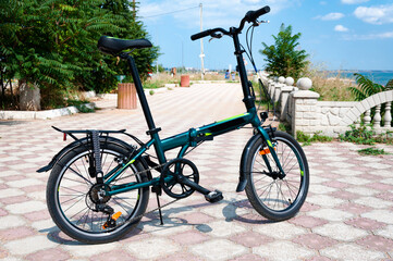 Fototapeta premium A folding bike stands on the Black Sea embankment.