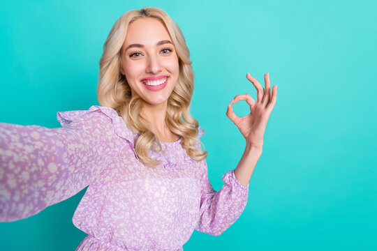 Photo of shiny sweet woman dressed purple blouse showing okey recoding self video isolated teal color background