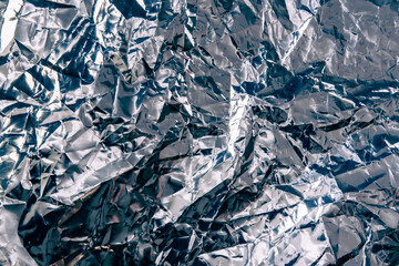Reflective crumpled foil texture background