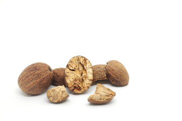 Dried whole and cracked nutmeg seeds or Myristica fragrans spice isolated on white background.