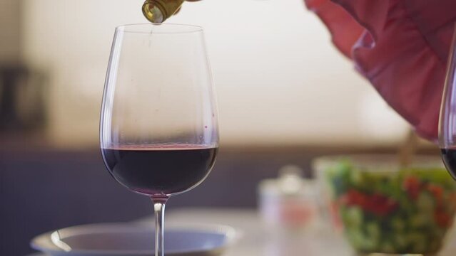Perfidious woman pours rat poison white powder into hated person glass with wine to revenge during dinner in kitchen slow motion closeup