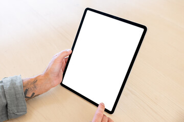 Person holding tablet computer vertically in hands, blank white screen mockup