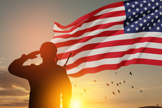 USA army soldier saluting with nation flag on a background of sunset or sunrise. Greeting card for Veterans Day, Memorial Day, Independence Day. America celebration. 3D-rendering.