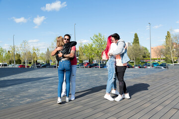 two couples of young friends hugging