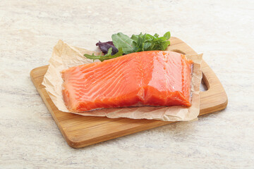 Raw salmon fillet over board