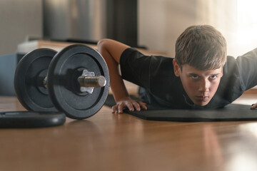 Young man workout at home.Determined teenage boy doing push ups in his living room