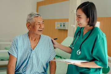 Hospitalized man lying in bed while doctor checking his pulse. Doctor or nurse examining senior...