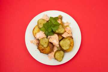 fresh baked salmon with fried potato and cucumber on plate