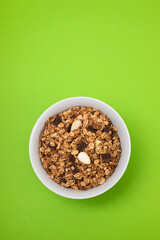 muesli with chocolate and nuts in white bowl