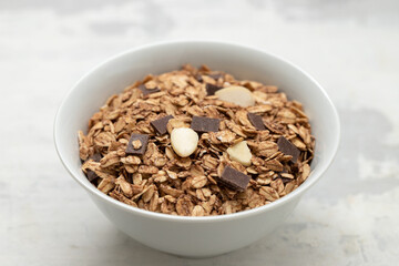 muesli with chocolate and nuts in white bowl