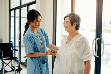 Fototapeta premium Asian nurse taking care and talking mature female patient in hospital. Healthcare concept.