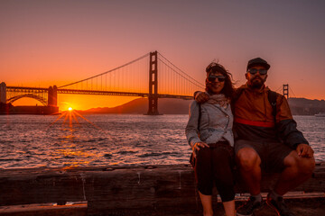 Fototapeta na wymiar A couple in red sunset at the Golden Gate of San Francisco. United States