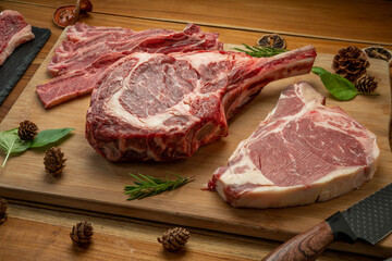 Mixed fresh meat Tomahawk beef, Cross Cut Short Ribs beef, Sliced brisket beef, T-bone steak beef on wooden background.