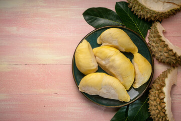 Fresh Durian fruit on black plate, Durian fruit with peel the King of fruits on wooden background.