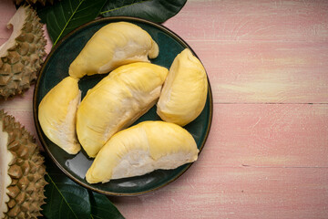 Fresh Durian fruit on black plate, Durian fruit with peel the King of fruits on wooden background.