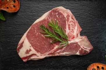 T-bone steak beef on black plate. Fresh T-bone steak beef with rosemary on wooden background, 