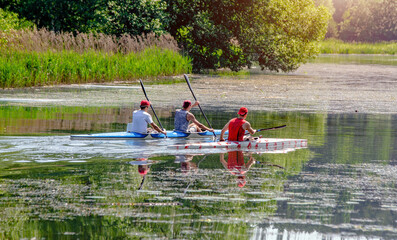 Three men floating in a canoe on the river
