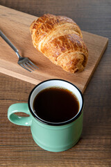 Croissant with a cup of full coffee,directly above	