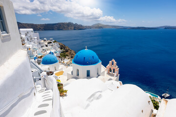 Fototapeta na wymiar View to the beautiful village of Oia, Santorini island, Greece, with blue domed churches and whitewashed houses