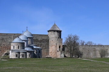 Fototapeta na wymiar The domes of the cathedral and churches, the fortress wall and the corner tower in the medieval fortress of Ivangorod on the border of Russia and Estonia in the Leningrad region.