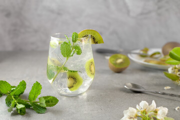 Kiwi mojito cocktail or caipirinha drink recipes with mint and ice in glasses close up. Summer cold drink and beverages. Lemonade with fresh kiwi. Rinfreshment unalcolic mocktail. Selective focus