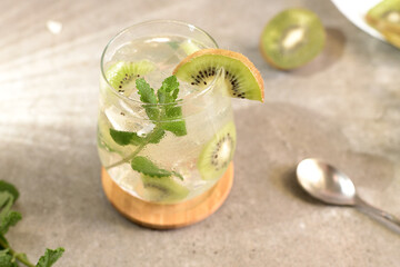 Kiwi mojito cocktail or caipirinha drink recipes with mint and ice in glasses close up. Summer cold drink and beverages. Lemonade with fresh kiwi. Rinfreshment unalcolic mocktail. Selective focus
