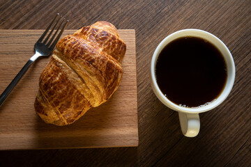 Croissant with a cup of full coffee,directly above	