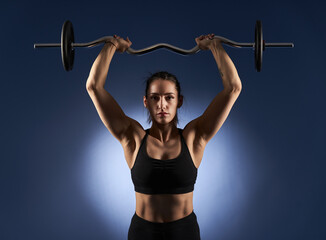 Woman doing shoulder workout with barbell