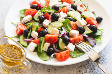 Greek salad of fresh cucumber, tomato, red onion, feta cheese and olives with olive oil. Healthy food, top view