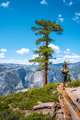 Foto op Plexiglas anti-reflex A young man with a brown jacket in Sentinel Dome looking at Upper Yosemite Fall, Yosemite National Park. United States © unai