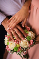 Obraz na płótnie Canvas Touching hands of groom and bride near bouquet of flowers. Wedding day concept. Wedding picture. Love is.