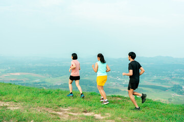 Asian man and woman trail runner running. On the high mountains, beautiful scenery. It's a trail running practice. on a bright day Behind is a beautiful mountain view..