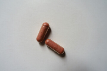 View of two pink capsules of PQQ dietary supplement from above