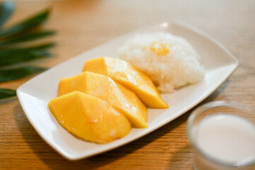 Delicious mango with sticky rice on a white plate. Asian Thai tropical desserts