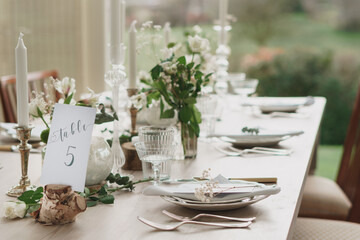Wedding or party table decorations. Dining table set up in romantic rustic vintage style. Landscape shot of wedding or party meal table decorations and set up.