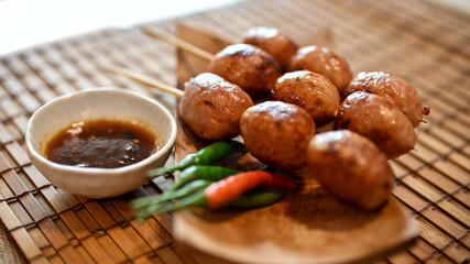 Thai grilled sausages or Isaan sausages on a bamboo placemat.